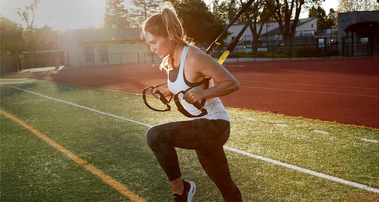 ورزشکار زن در حال تمرینات ورزش تی آر ایکس